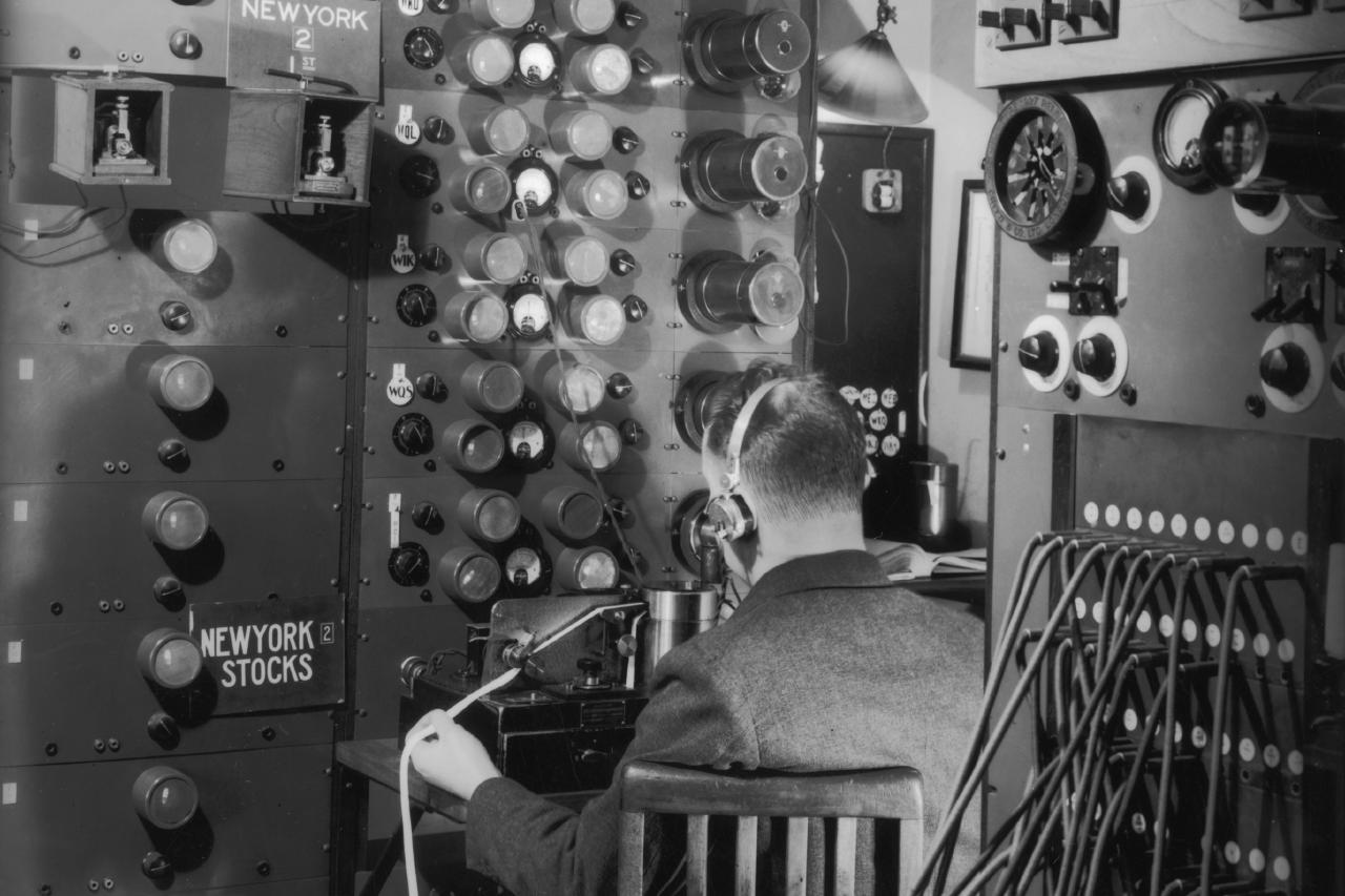 Black and white photograph of a vintage ticker tape operator.